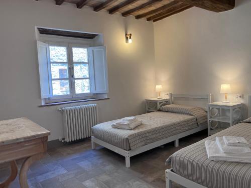 um quarto com 2 camas e uma janela em Buongiorno Maestra di Monteverdi Marittimo, Borgo di Canneto em Canneto