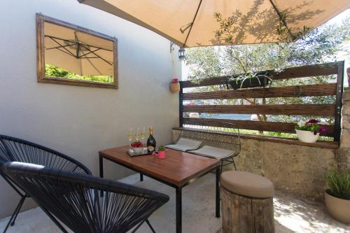 Un patio con una mesa y sillas y una ventana. en Holiday house VIDA, en Biograd na Moru