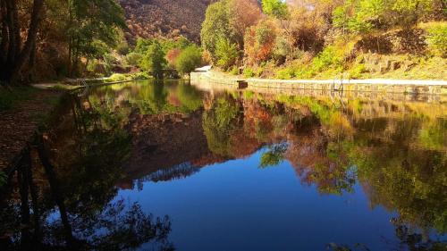 un río con el reflejo de árboles en el agua en La Portilla de Cabezo, en Cabezo