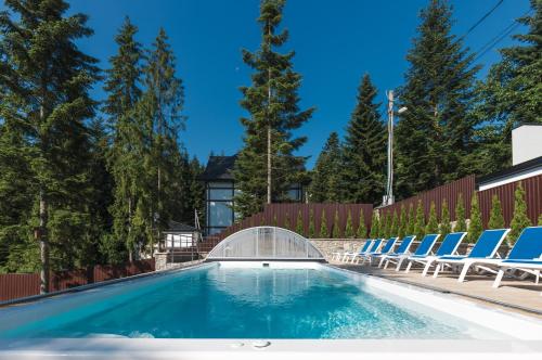 einen Pool mit Stühlen und einer Brücke in der Unterkunft Апарт- готель SunRay in Schidnyzja