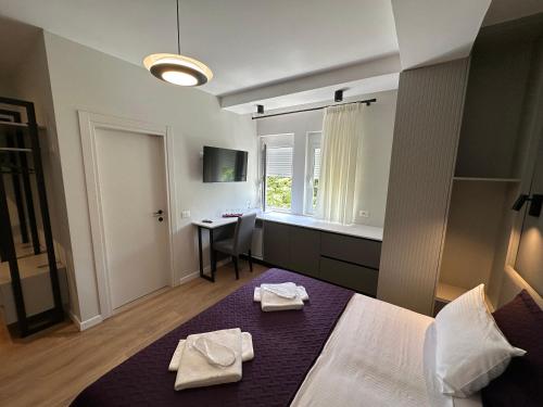 a bedroom with a bed with two towels on it at Soin Rooms in Tirana