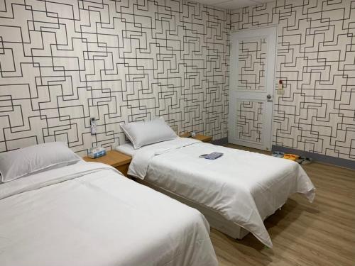 南竿鄉的住宿－福華民宿，配有带图案墙壁的客房内的两张床