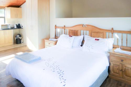 ein Schlafzimmer mit einem großen weißen Bett mit weißen Kissen in der Unterkunft Shalom Self Catering in Kleinmond