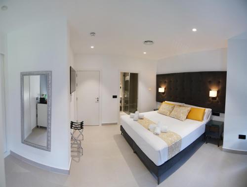 a bedroom with a large bed and a mirror at Suites Puerto Valencia in Valencia