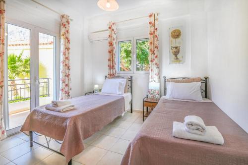 a bedroom with two beds and a window at Charalampos in Plakias