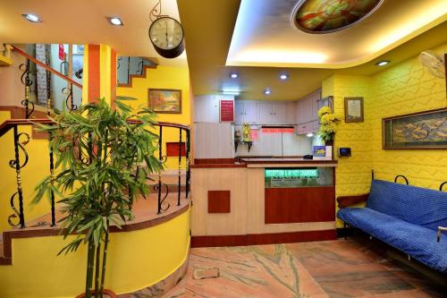 Tulip 1bhk Apartment by Hotel Airways في كولْكاتا: غرفة معيشة مع أريكة زرقاء ومطبخ