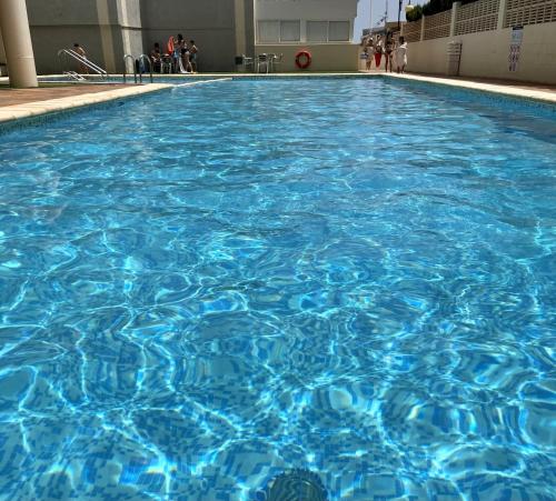 una gran piscina de agua azul en un edificio en Primera línea con piscina en Calpe, en Calpe