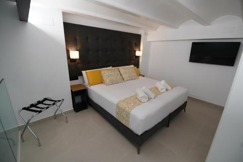 a bedroom with a bed and a television in it at BET Apartments - Suites Puerto Valencia in Valencia