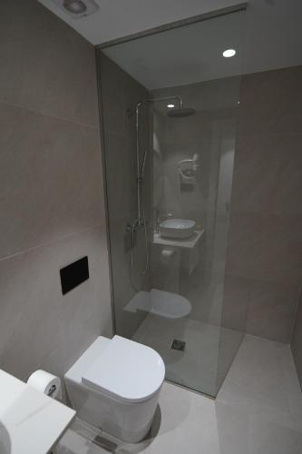 a bathroom with a shower and a toilet and a sink at BET Apartments - Suites Puerto Valencia in Valencia
