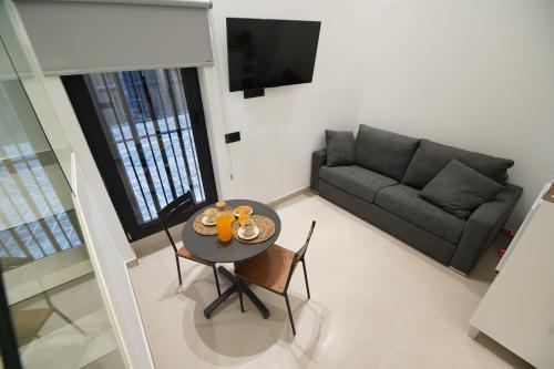 uma sala de estar com uma mesa e um sofá em Suites Puerto Valencia em Valência
