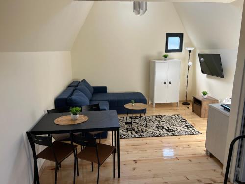 uma sala de estar com um sofá azul e uma mesa em Planinske Kuće Grocka em Grocka