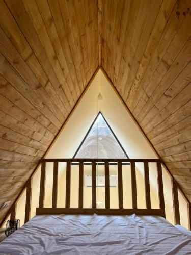 Cama en habitación con ventana grande en Planinske Kuće Grocka, en Grocka