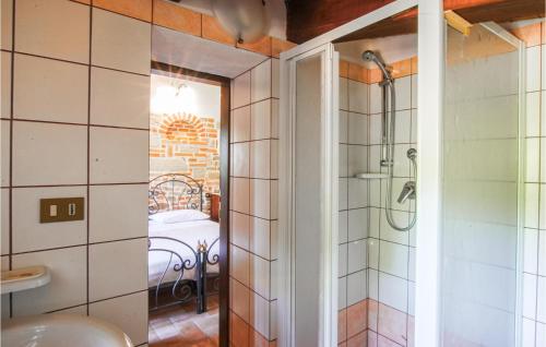 Cette chambre comprend un lit et une salle de bains pourvue d'une douche. dans l'établissement Gorgeous Apartment In Monte Rinaldo With Wifi, à Monte Rinaldo