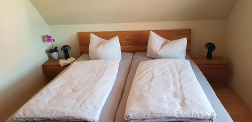two beds in a room with white sheets and pillows at Suite Kleine Auszeit in Liepgarten