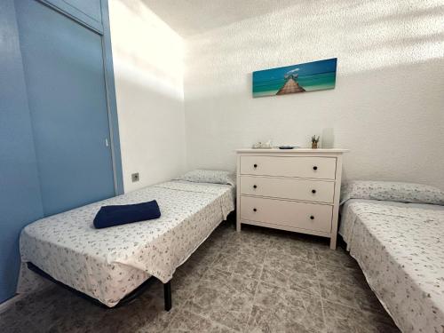 sypialnia z 2 łóżkami i komodą z szufladą w obiekcie Edificio Thailandia 2, 9G w mieście Santa Pola