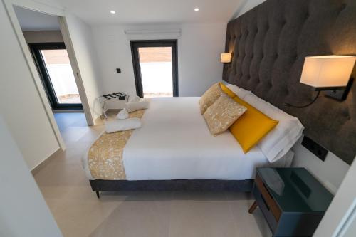 a bedroom with a large white bed with yellow pillows at BET Apartments - Suites Puerto Valencia in Valencia