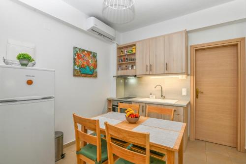 a kitchen with a table and chairs and a refrigerator at Antonia in Plakias