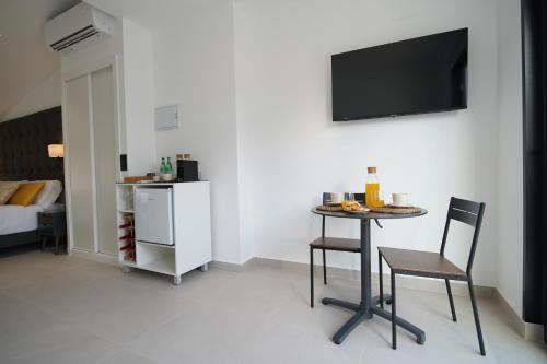 a room with a small table and a television on the wall at BET Apartments - Suites Puerto Valencia in Valencia