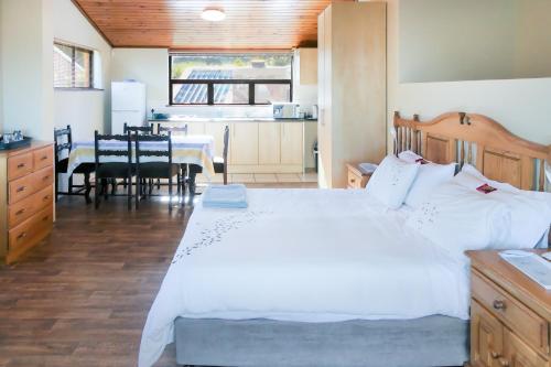 a bedroom with a large bed and a dining room at Shalom Self Catering in Kleinmond
