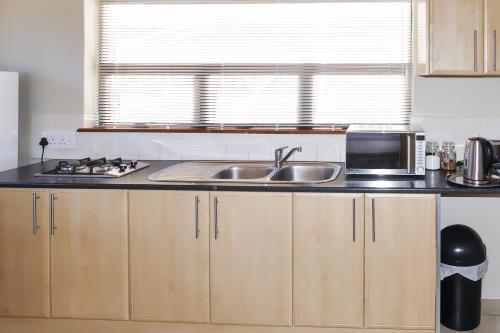 a kitchen with a sink and a microwave at Shalom Self Catering in Kleinmond