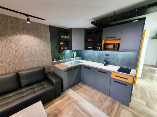 uma cozinha com um sofá, um lavatório e um balcão em Stonefall Tenerife Holiday Apartment Las Americas em Playa Fañabe