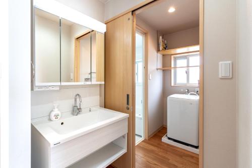 a bathroom with a sink and a washing machine at ザ・ヴィラス待遠屋 in Bise