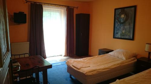 a bedroom with a bed and a desk and a window at Noclegi Dobry Sen in Samborzec