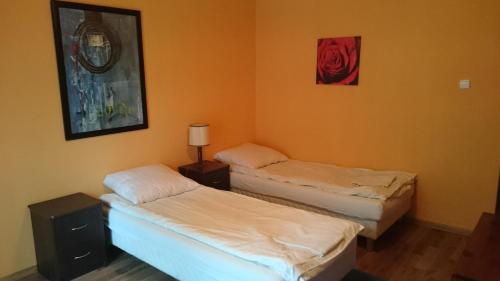 Samborzec的住宿－Noclegi Dobry Sen，橙色墙壁客房的两张床