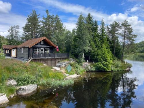 a cabin on the shore of a river at Holiday cottage with sauna close to Kjeragbolten-Bedding included in Tjørhom