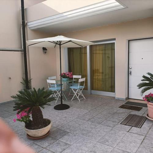 a patio with an umbrella and a table and chairs at Sunny House Fourteen in Assemini
