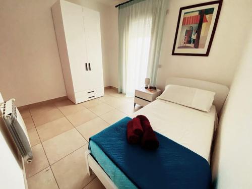 a bedroom with a bed with a red hat on it at Sunny House Fourteen in Assemini