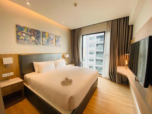 ein Hotelzimmer mit einem Bett und einem Flachbild-TV in der Unterkunft YuStay Superior Luxury Condotel Central District 1 in Ho-Chi-Minh-Stadt