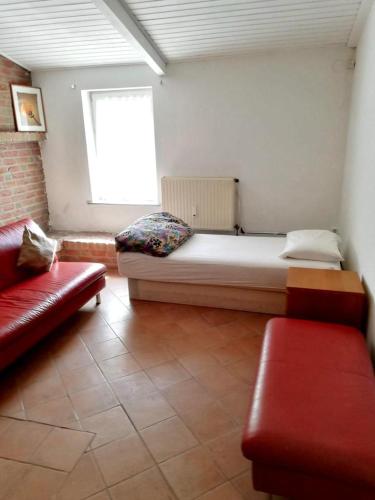 a bedroom with a bed and a couch and a window at Apartment in Nijmegen voor 3 personen in Kranenburg