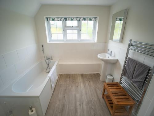 a white bathroom with a tub and a sink at Helmsdale in Burley