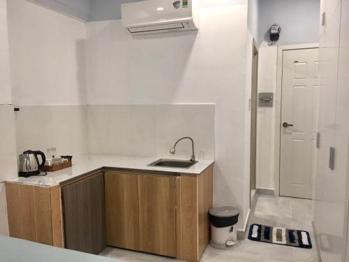 a small kitchen with a sink and a microwave at Saigon Cozy Home " At BuiVien Walking Street " - Self Check In in Ho Chi Minh City
