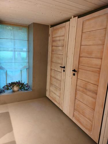 een kamer met twee houten deuren en een raam bij Metsatuule puhkeküla in Hiiumaa