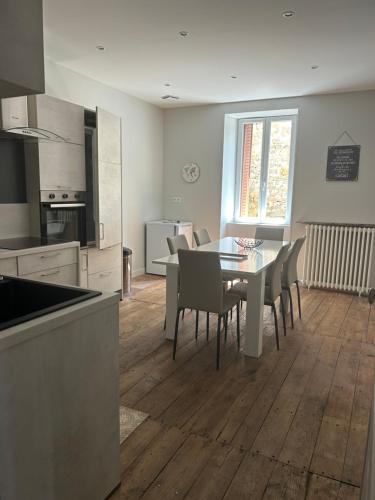 une cuisine et une salle à manger avec une table et des chaises dans l'établissement Les Ramandes Appartements au cœur du village, à Marcillac-la-Croisille