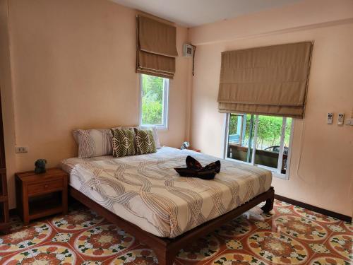 1 dormitorio con 1 cama en una habitación con ventanas en Baan NomTham, en Ko Lanta