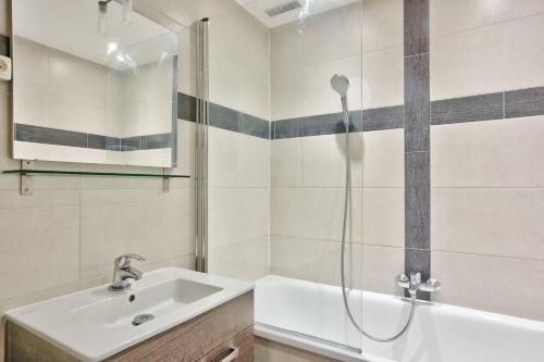 een badkamer met een wastafel en een douche bij Appartement Quartier Parc Monceau in Parijs