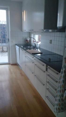 a kitchen with white cabinets and a sink and a window at 12 min from Malmö / Lund in Staffanstorp