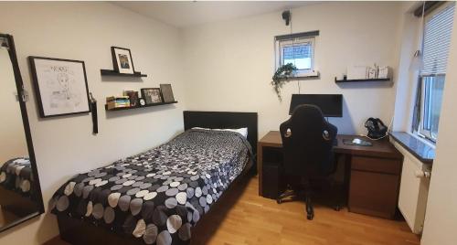 a bedroom with a bed and a desk with a computer at 12 min from Malmö / Lund in Staffanstorp