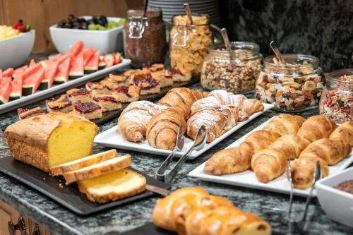 a buffet filled with different types of bread and pastries at Hotel Kesslwirt in Ciardes