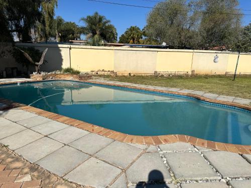 una piscina en un patio con agua azul en Silverton Private Apartment en Pretoria