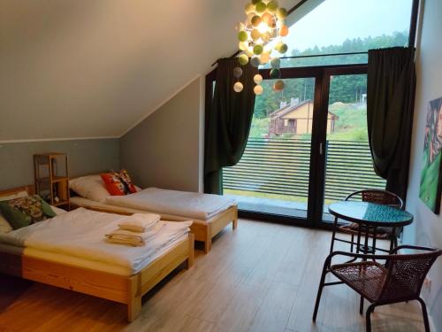 um quarto com 2 camas e uma grande janela em Willa Powolutku em Ostrzyce