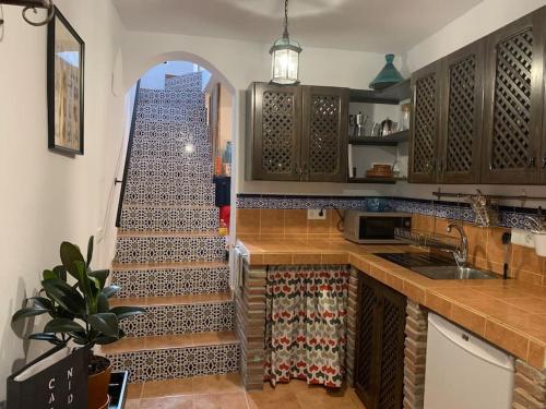 a kitchen with a staircase leading up to a stair case at Townhouse in Canillas de Aceituno in Canillas de Aceituno