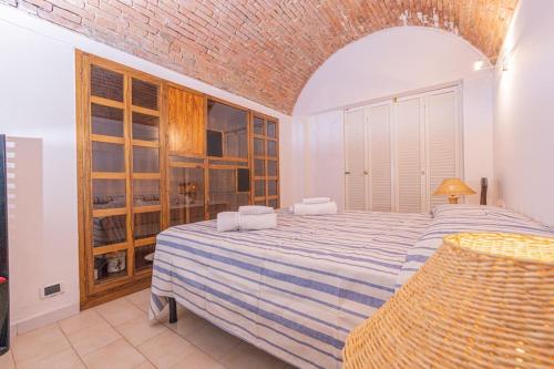 a bedroom with a large bed with a blue and white blanket at Affitti Brevi Toscana - Forte Militare Talamonaccio in Fonteblanda
