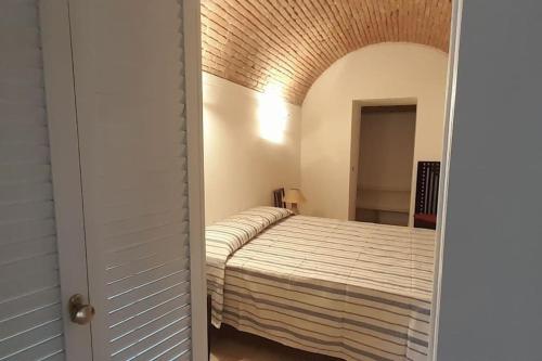 a bedroom with a bed and an open door at Affitti Brevi Toscana - Forte Militare Talamonaccio in Fonteblanda