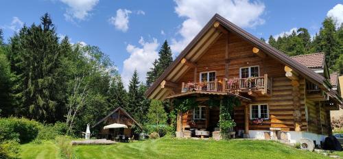 a log house with a balcony and a porch at Chalet le Dorf in Nötsch