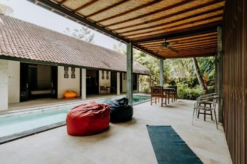 an outdoor patio with a pool and a house at VILLA Surya 3 rooms , waterpool, near the ocean in Candidasa