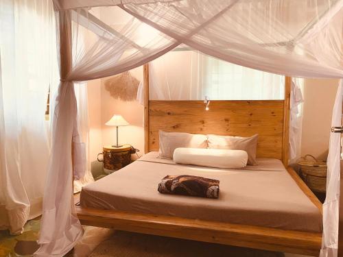 a bedroom with a bed with a canopy at Mama Root in Kizimkazi